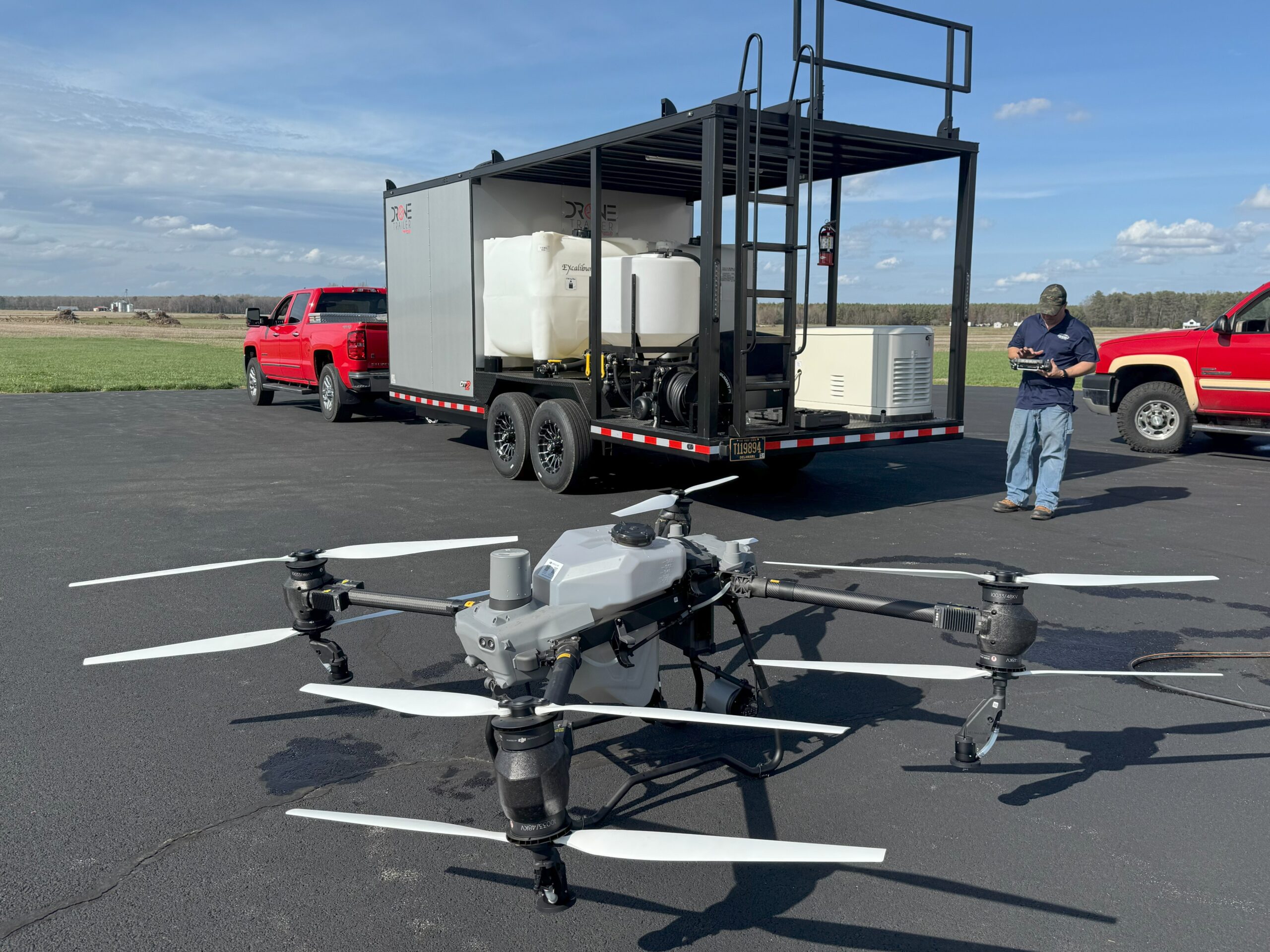 Drone on ground with trailer and pilot in background